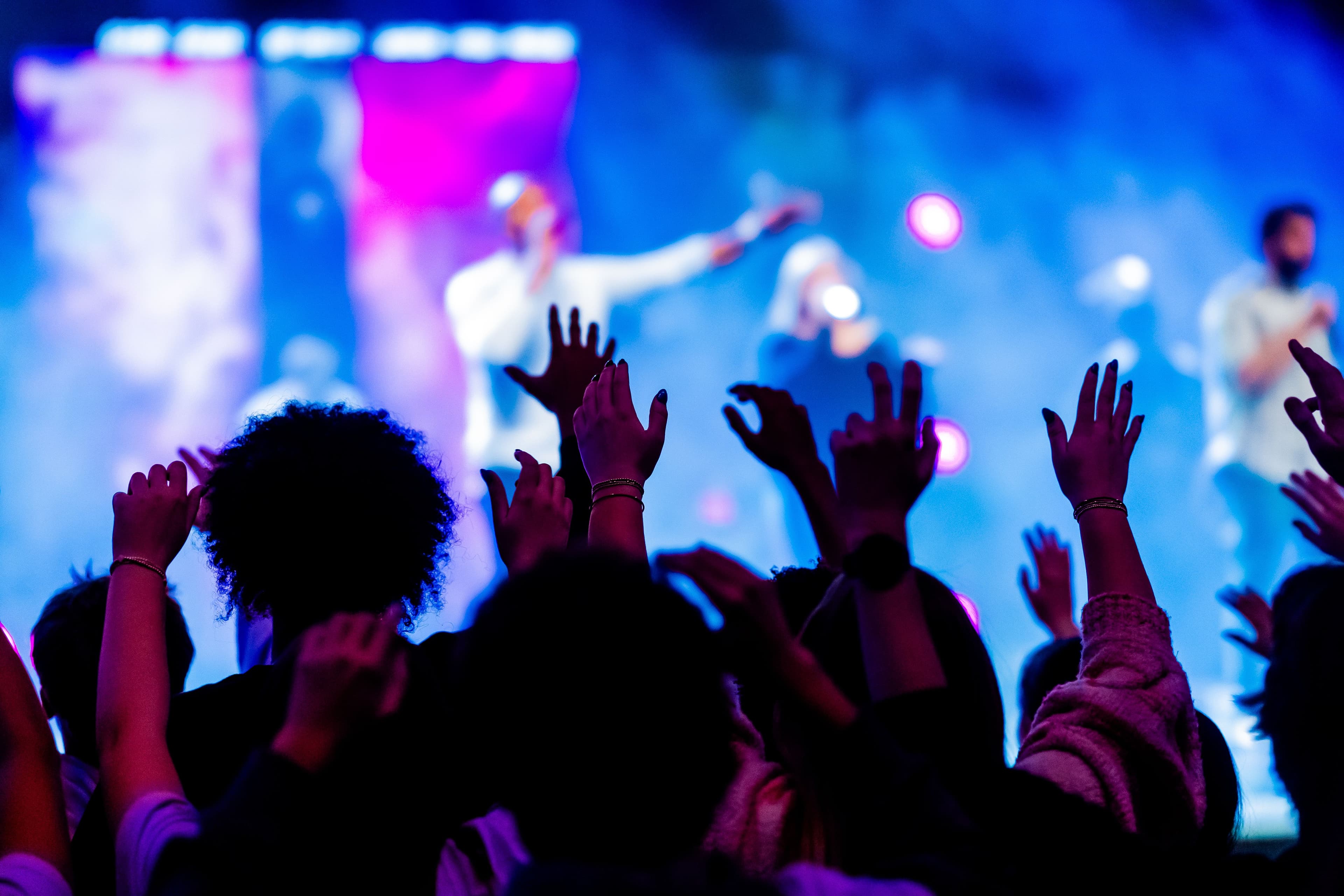 Festival crowd worshiping with hands raised