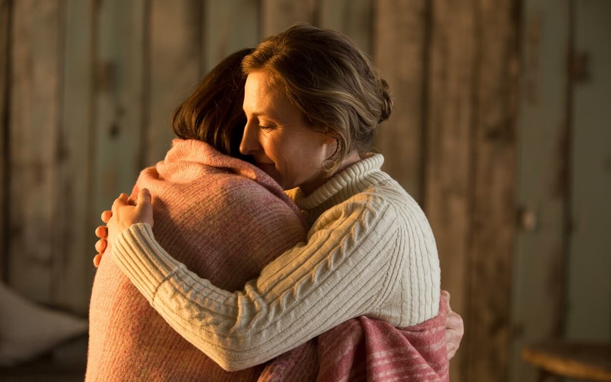 Two women embracing in a quiet moment of care and encouragement