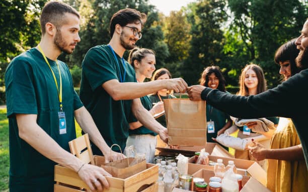 Volunteers distributing groceries and essential supplies outdoors